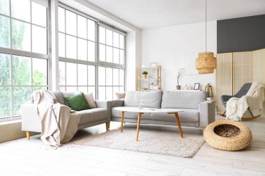 Oturma odasının içinde kanepeler ve kahve masası var.