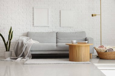 Gri kanepede ekoseli aydınlık oturma odasının içi.