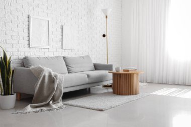 Gri kanepede ekoseli aydınlık oturma odasının içi.