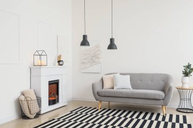 Modern oturma odasının içinde şık bir şömine ve kanepe var.