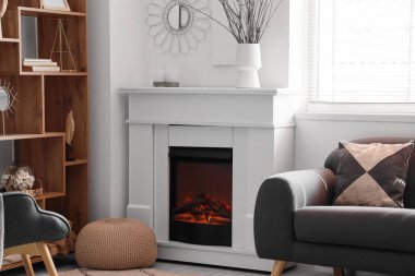 Şık bir şömine, raflar ve odada bir kanepe.