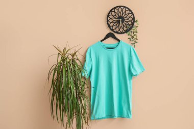 Bej arkaplanda asılı şık mavi tişört