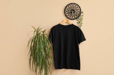 Bej arkaplanda asılı şık siyah tişört