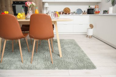 Modern mutfakta şık bir halıda yemek masası servis ettim.