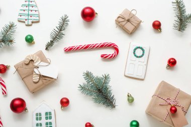 Topları olan Noel ağacı dalları, hediye kutuları ve beyaz arka planda şeker kamışı