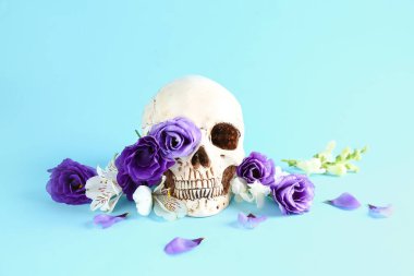 Mavi arka planda güzel çiçekli insan kafatası