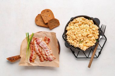 Yağda yumurta kızartma tavası ve arka planda domuz pastırması.