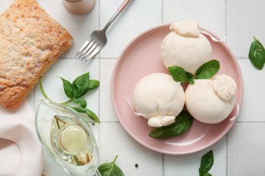 Beyaz fayanslı fesleğen ve yağlı lezzetli Burrata peyniri tabağı