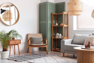 Oturma odasında rahat koltuk, kanepe ve katlanır ekran.