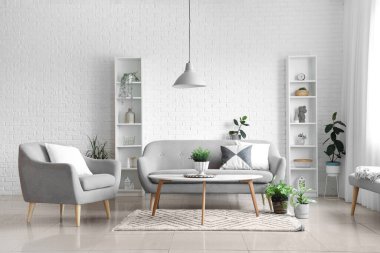 Oturma odasında rahat bir koltuk, kanepe ve masa.