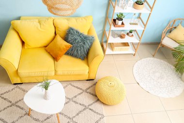 Oturma odasında rahat bir koltuk, kanepe ve masa.