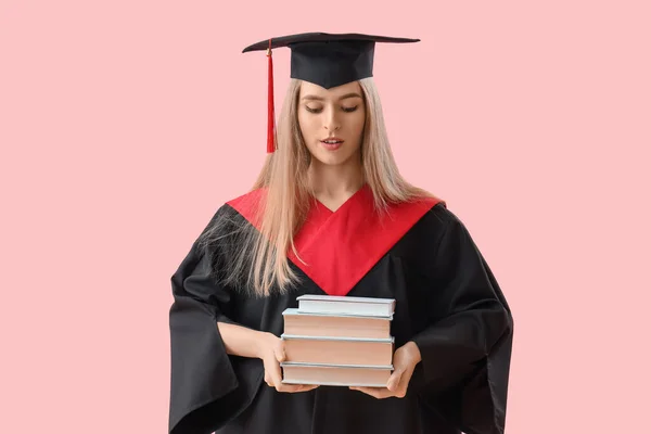 ピンクのバックグラウンドの本を持つ女性大学院生 — ストック写真