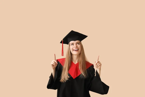 Female Graduate Student Pointing Something Beige Background — Stock Photo, Image