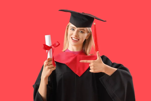 Estudiante Graduada Señalando Diploma Fondo Rojo —  Fotos de Stock