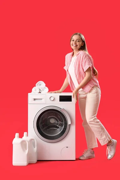 Muito Jovem Mulher Perto Máquina Lavar Roupa Fundo Vermelho — Fotografia de Stock