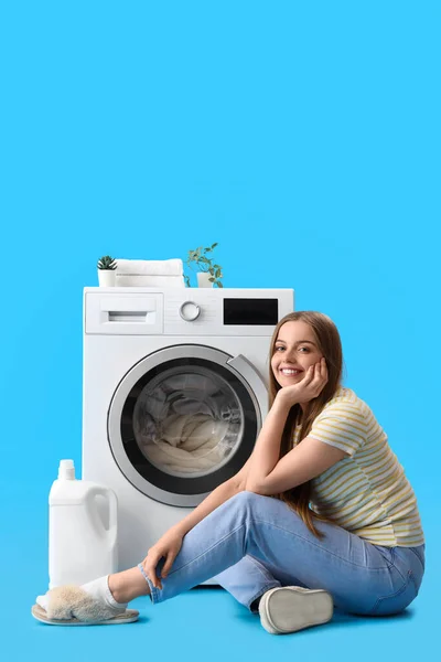Mulher Bonita Sentada Perto Máquina Lavar Roupa Fundo Azul — Fotografia de Stock
