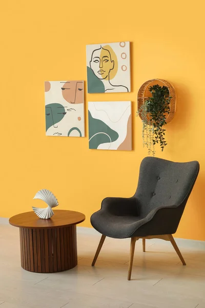 Grauer Sessel Und Hölzerner Couchtisch Neben Orangefarbener Wand Mit Verschiedenen — Stockfoto