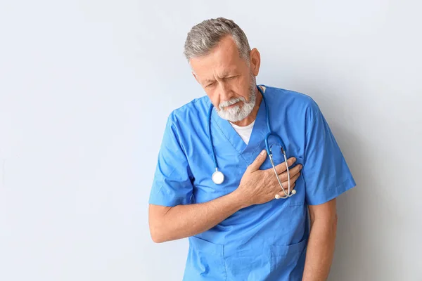 軽い背景で心臓発作を起こしている成熟した医師 — ストック写真
