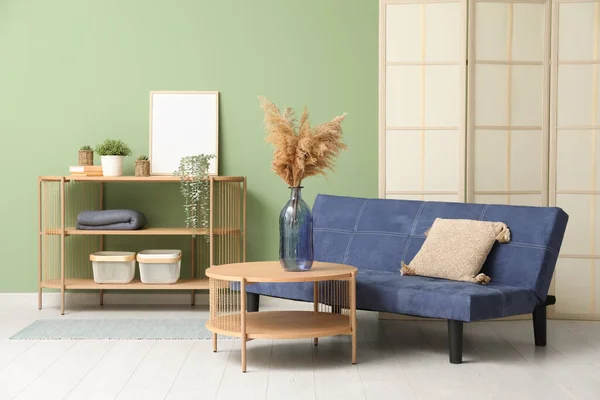 Holztisch Mit Regal Und Couch Der Nähe Der Grünen Wand — Stockfoto