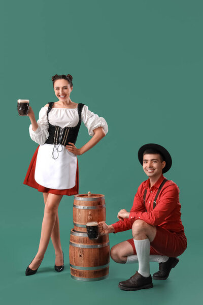 Молодая пара в традиционной немецкой одежде с пивом на зеленом фоне