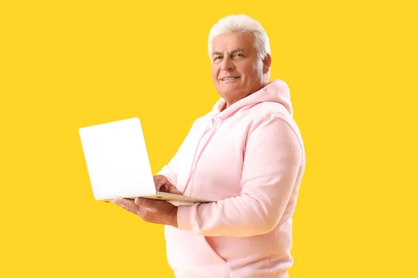 Старший Мужчина Ноутбуком Желтом Фоне — стоковое фото
