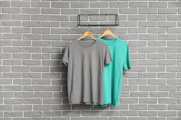 Stijlvolle Shirts Hangend Aan Grijze Bakstenen Muur — Stockfoto