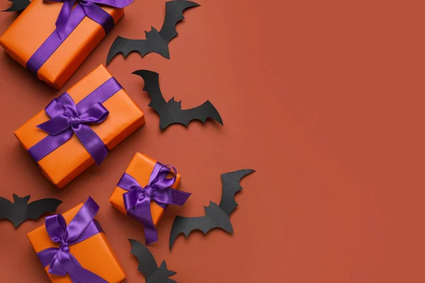 Composition with gift boxes and paper bats for Halloween on brown background