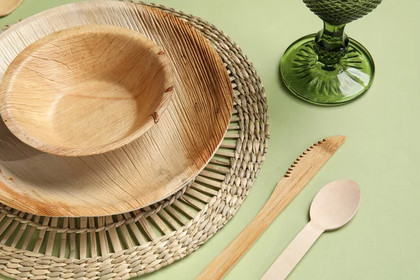 緑の背景の異なる木製のテーブルウェアとガラス クローズアップ — ストック写真
