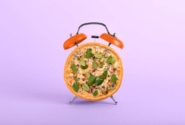 Alarm saati kolajı ve leylak arka planda lezzetli pizza.