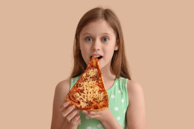 Bej arka planda pizza yiyen küçük kız.