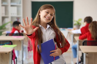 Sınıfta kitap okuyan küçük bir kız.