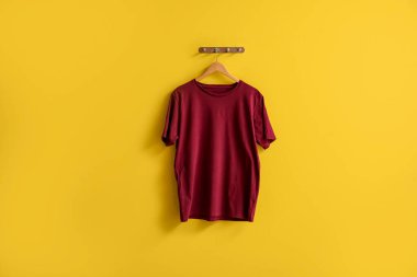 Sarı arka planda asılı şık kırmızı tişört