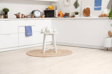 Çay takımlı küçük masa ve modern mutfakta hasır halıda zephyr.