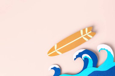 Kağıt dalgaları ve pembe arka planda mini sörf tahtası olan yaratıcı kompozisyon