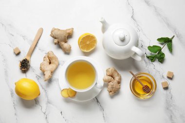 Beyaz arka planda bal ve zencefilli çay.