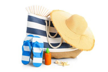 Beyaz arka planda izole edilmiş plaj aksesuarlarıyla bir şişe güneş kremi.