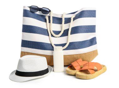 Beyaz arka planda izole edilmiş plaj aksesuarlarıyla bir şişe güneş kremi.