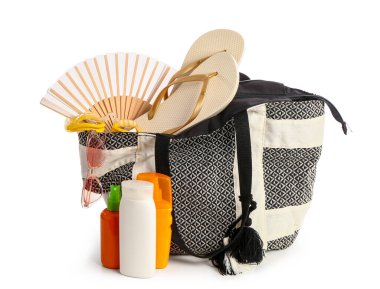 Beyaz arka planda izole edilmiş plaj aksesuarlarıyla güneş kremi şişeleri.