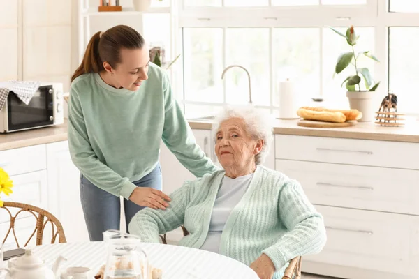 Torunuyla birlikte mutfakta kıdemli bir kadın.