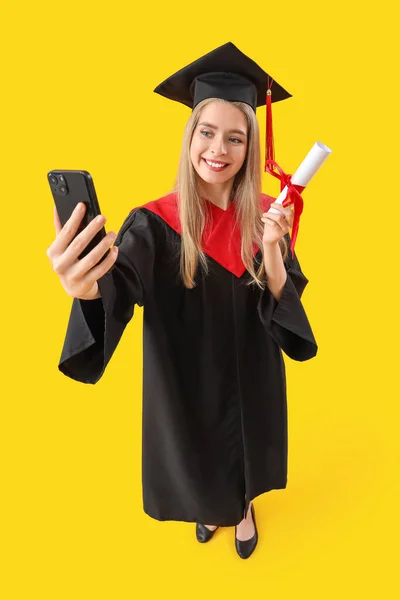 Vrouwelijke Afgestudeerde Student Met Diploma Selfie Gele Achtergrond — Stockfoto