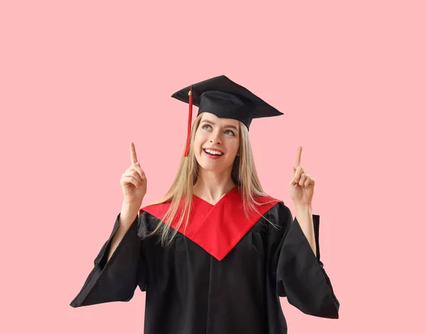 Kobieta Absolwentka Wskazując Coś Różowym Tle — Zdjęcie stockowe