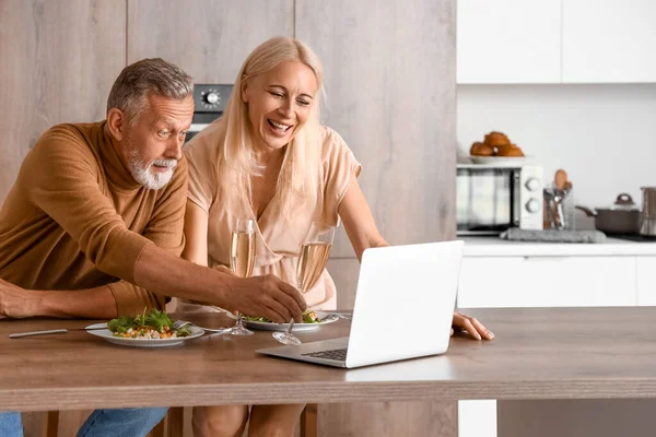 Olgun bir çift mutfakta yemek yiyor.