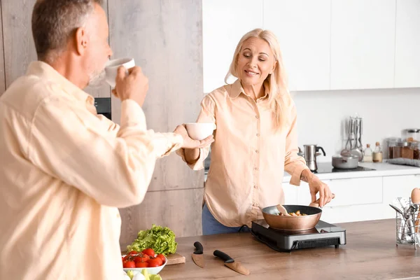 Mature Man Giving Cup Coffee His Wife Kitchen — Stock Photo, Image