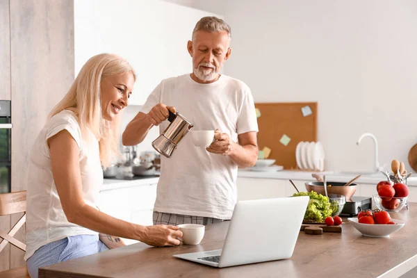 Mature couple drinking coffee in kitchen