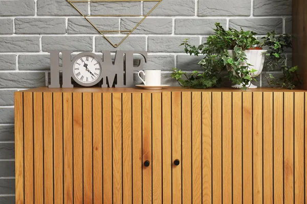Stylish Wooden Cabinet Clock Houseplant Grey Brick Wall — Stock Photo, Image