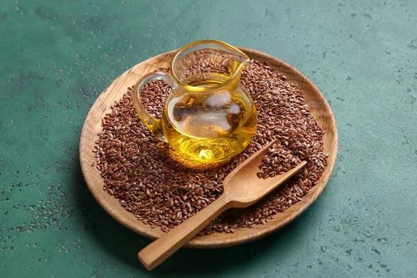 Yeşil arka planda tohumları olan keten yağı ve tabak.