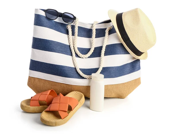 Beyaz arka planda izole edilmiş plaj aksesuarlarıyla bir şişe güneş kremi.