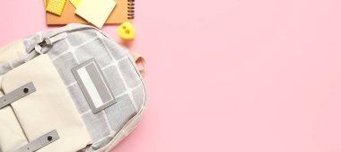 Okul çantası ve pembe zemin üzerinde farklı kırtasiye malzemesi metin için yer, üst görünüm