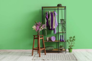 Raflar, giysiler ve taburesi olan şık bir oda.