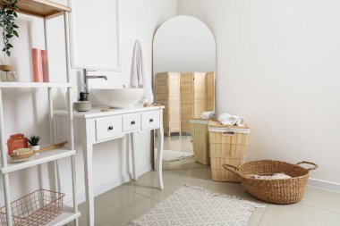 Lavabo lavabosu, raf ünitesi ve aynalı bir masa.